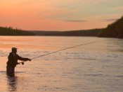An angler unfurls a spey cast in low light on the Ponoi.