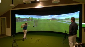 Manchester CC head golf professional Todd McKittrick watches a member take his hacks on on MCC’s aboutGolf SimSurround Curve golf simulator (Photo: Gil Talbot Photography)