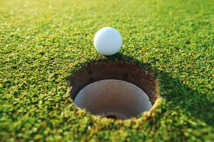 Golf Ball Sitting on Edge of Hole