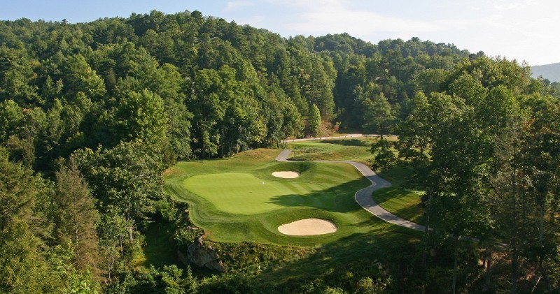 The short, captivating par-3 15th drops down over a Mud Creek ravine to a three-stepped green.