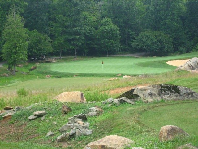 The boomerang green at the par-3 3rd, with the back lobe tucked behind an elevated bunker.