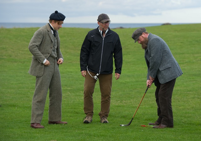 Director Jason Connery gives old time putting tips to his principals. 