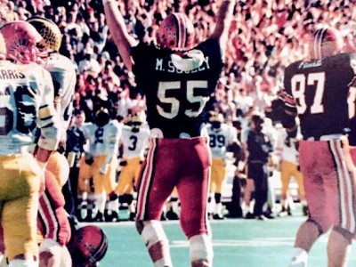 Mike Scully raising hands to celebrate during college game.