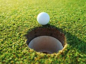 Golf Ball Sitting on Edge of Hole